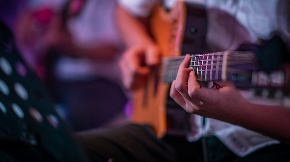 Close up of guitarist playing acoustic guitar